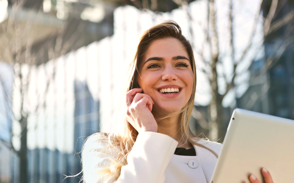 Uśmiechnięta kobieta w trakcie rozmowy telefonicznej — naturalny głos asystenta